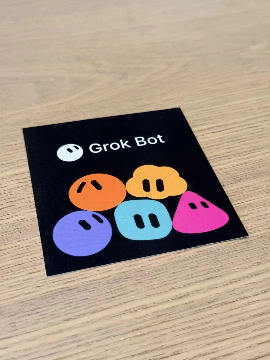 A Grok Bot card with five colorful bot characters on a wooden table